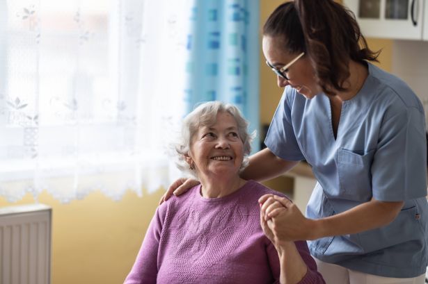 imported-0_A-captured-smile-of-an-older-woman-in-a-pink-sweater-tenderly-held-by-the-hand-of-a-younger-nurse-in-a-blue-uniform-The.jpg