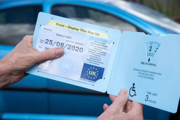 imported-0_Womans-hands-holding-a-Blue-disabled-driver-Badge-parking.jpg