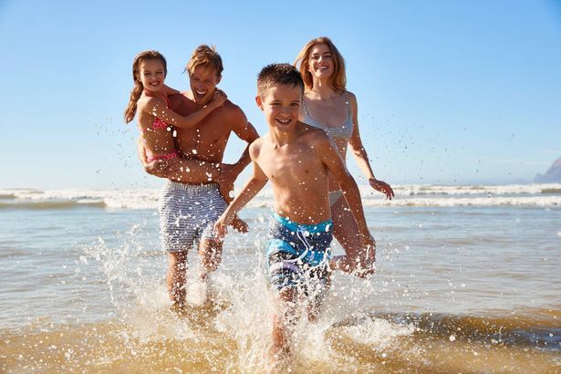 imported-0_Family-On-Summer-Beach-Vacation-Run-Out-Of-Sea-Towards-Camera.jpg