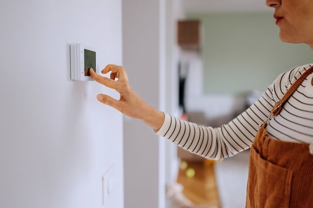 imported-3_Casually-clothed-woman-setting-up-temperature-on-smart-thermostat-at-home.jpg