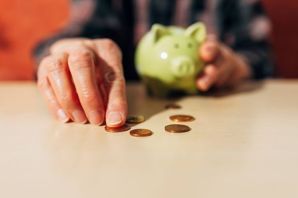 imported-0_senior-women-Hand-collecting-coins-on-a-table-with-a-piggy-bank-in-the-background.jpg